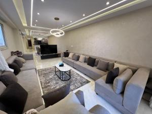 Al Ma‘şarahشقة فندقية فاخرة的带沙发和电视的大型客厅