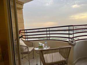 Al Ma‘şarahشقة فندقية فاخرة的阳台配有桌椅。