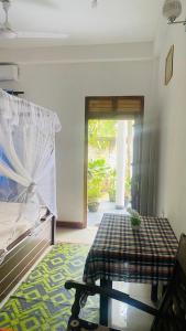 坦加拉Silence Paradise的客房设有床、桌子和窗户。