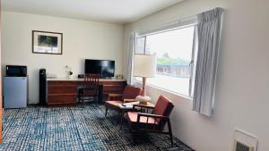 新奥尔良市Curly Redwood Lodge的酒店客房设有桌子、椅子和窗户。