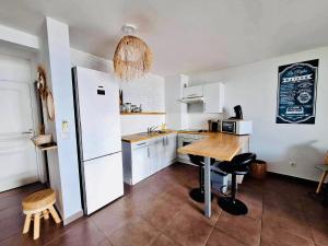 普纳奥亚La vue de rêve的厨房配有木桌和冰箱。