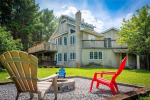 布雷斯布里奇Lovely Muskoka Waterfront Cottage-Hot tub & Sauna!的两把椅子坐在房子前面