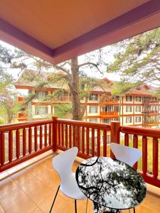 碧瑶The Forest Lodge at Camp John Hay with balcony and parking privately owned unit 272的阳台配有桌椅和一棵树。