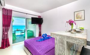 攀瓦海滩Mango Tree Villa的海景卧室 - 带紫色床