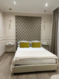 罗马NLM Boutique Suites的一间卧室配有一张大床和两张黄色枕头