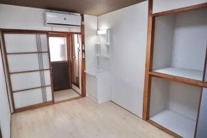 大阪TSUBAME 202 staying private home的一间空房间,有玻璃架子和门