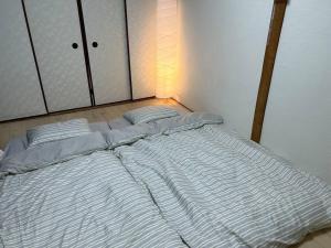 大阪TSUBAME 202 staying private home的一张大白床,坐在房间里