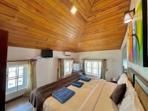 努沃勒埃利耶Royal Pearl Hills的一间卧室设有一张带木制天花板的大床