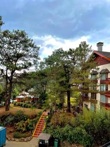 碧瑶Forest Lodge at Camp John Hay privately owned - Deluxe Queen Suite with balcony and Parking 269的一座房子,旁边是一座橙色的楼梯