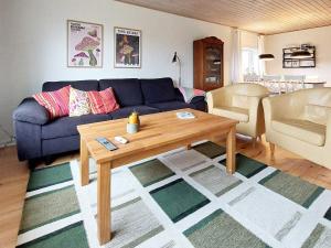 斯凯恩Holiday home Skjern XXI的客厅配有蓝色的沙发和桌子