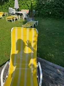 格伦德尔湖迪莱克特湖畔公寓的坐在黄椅上的人的影子