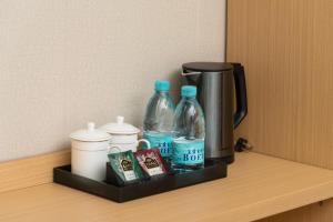 广州华旅酒店(广州北京路步行街省人民医院店)的一个带两瓶水的架子和一个咖啡壶