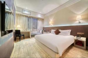 杭州汉象图书音乐酒店的卧室配有一张白色大床和一张书桌