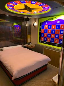 Iwakiriホテル　プレリュード的一间设有一张床的房间和墙上的电子游戏
