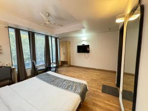 新德里Hotel The Centrum - NFC New Delhi的一间卧室配有一张床和一台平面电视