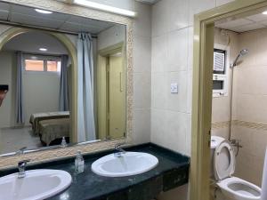 阿布扎比The Family的浴室设有2个水槽和镜子
