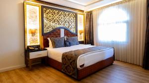 安塔利亚Can Adalya Palace Hotel的一间卧室配有一张带大床头板的床