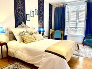 贝尔热拉克Maison B的一间卧室配有一张带蓝色窗帘的大床