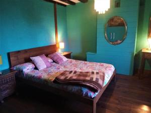 GalarretaKukuma Etxea Habitaciones con derecho a cocina的一间卧室配有一张带紫色枕头和镜子的床