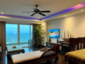 南芭堤雅View Talay 7 Seaview Apartments的客厅配有吊扇和电视。