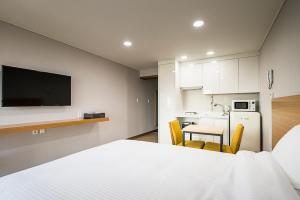 西归浦市W海洋旅馆的一间卧室配有一张床铺和一张桌子,还设有一间厨房