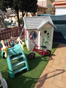 加尔达Garda City Home Family Apartments的一个带玩具屋和自行车的小型儿童游乐场