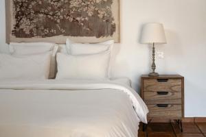 哈隆Cuatre Finques的一间卧室配有一张带白色床单和一盏灯的床。