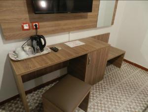 阿尔及尔SAMIR HOTEL的配有电视的客房内的一张木桌