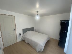 厄尔河畔帕西Appartement confort的一间白色的卧室,配有床和门