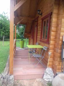 JouheLe petit chalet jurassien的小木屋的门廊配有桌椅