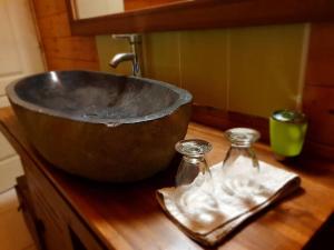 拉普兰德帕尔米斯特Chalet Chaleureux的木柜台上的金属碗,装有两瓶玻璃瓶