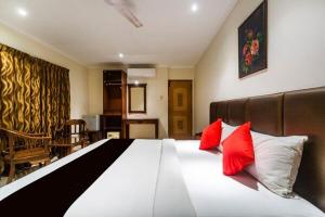 钦奈Blossoms Hotel & Service Apartments的一间卧室配有一张大床和两个红色枕头