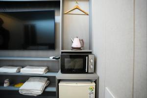 首尔Shinchon Y Hotel的一间配备有微波炉和电视的客房