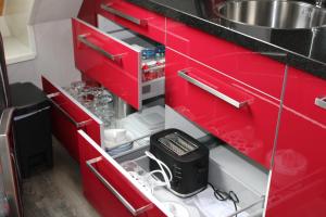 坎珀兰Hoeve Hofwijk的一间带红色橱柜和水槽的厨房