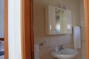 孔迪镇Beach House的浴室设有白色水槽和镜子