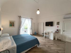 波西塔诺Regina Margherita的一间卧室配有一张床、一张书桌和一台电视