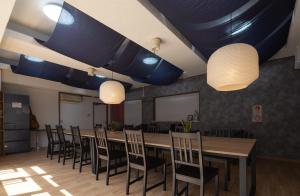 高松Hostel JAQ takamatsu的一间会议室,配有长桌子和椅子