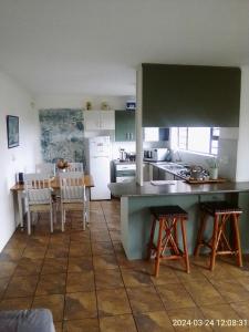 贝蒂湾Streams Cottage的厨房以及带桌椅的用餐室。