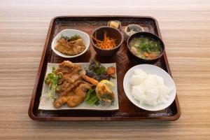 高松Hostel JAQ takamatsu的盘子,盘子上放着肉,蔬菜和米饭