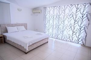 多布拉沃达Apartmani ARIANA的一间卧室配有一张床和图案墙壁