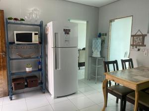 大坎皮纳Duplex agradável com Ar, Internet, Netflix e Estacionamento的厨房配有白色冰箱和桌子