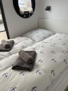 石勒苏益格Hausboot Claudia Schleswig的一间卧室配有两张床,床单上用蓝色字母装饰