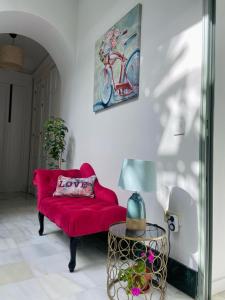 赫雷斯-德拉弗龙特拉La Gitanilla Alojamiento & Encanto Jerez的客厅配有红色的沙发和一张自行车照片