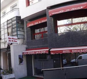 阿尔及尔DAR EL IKRAM HOTEL的前面有红色标志的建筑