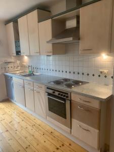 巴特莱辛哈尔FeWo Alpensteinbock的厨房配有白色橱柜和炉灶烤箱。