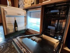 伊尔梅瑙Waldhütte Allzunah的配有一瓶葡萄酒的开放式冰箱
