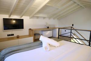 希俄斯Castrusso Castle apartments的一间卧室设有一张带平面电视的床。