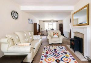 伦敦London Stratford Holiday Home的客厅配有两把白色椅子和壁炉