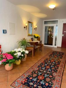 巴特拉斯费Hotel Wittgensteiner Hof的客厅配有地毯和鲜花桌
