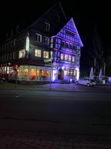 巴特拉斯费Hotel Wittgensteiner Hof的建筑前方有蓝色的灯光